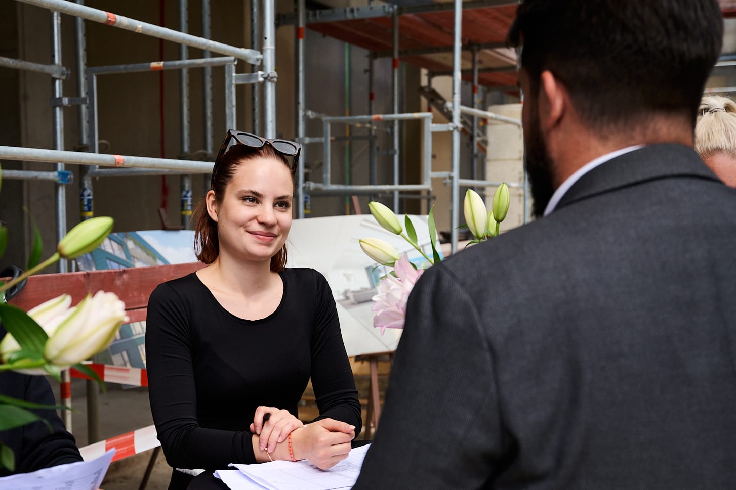 About Us 2 a woman sitting at a table with a man in a suit