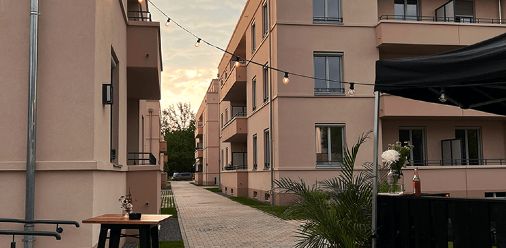 Moderne Wohnanlage mit Lichterketten im Außenbereich bei Sonnenuntergang, Deutschland.